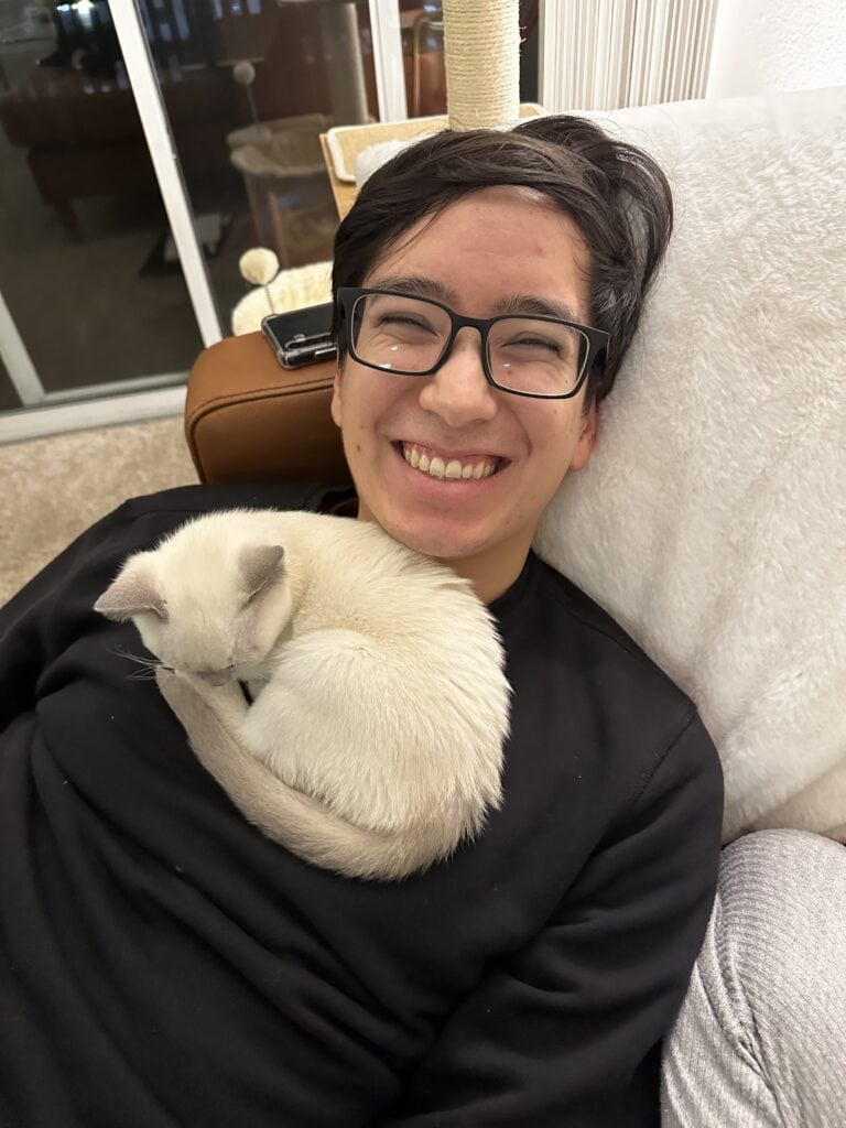 Man with white kitten curled up on his chest