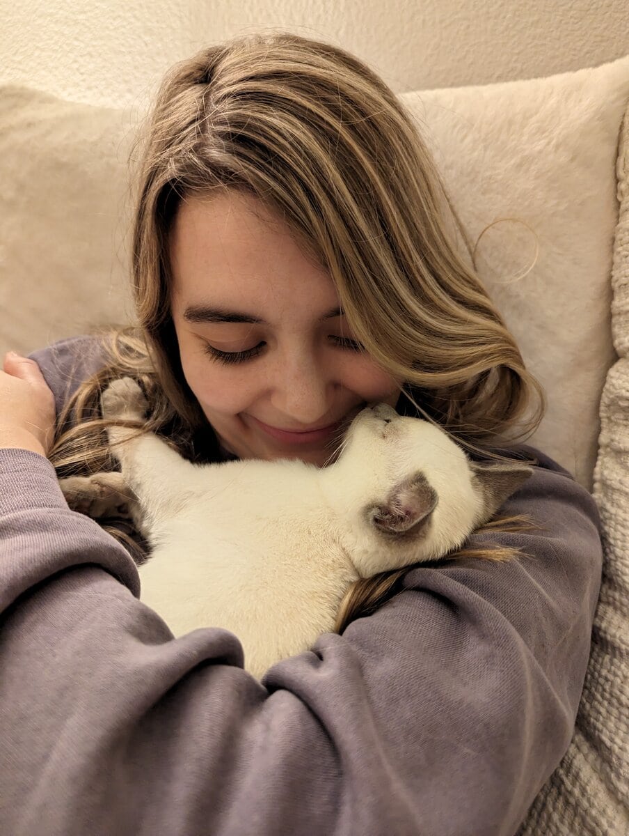 Woman holding white kitten