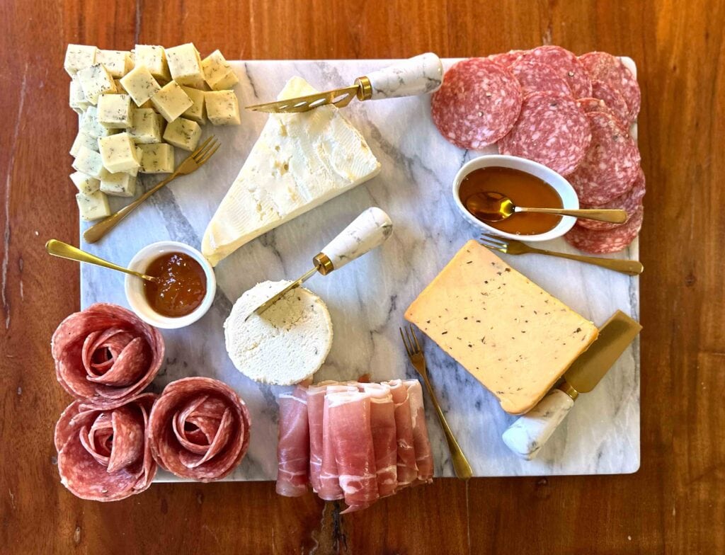 Charcuterie board with cheeses, dips, and charcuterie.