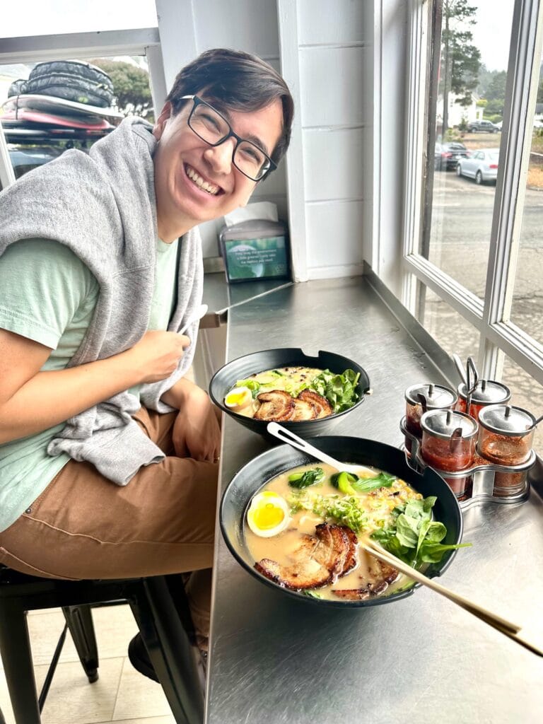 Man seated at window bar enjoying ramen and dumplings at Gnar Bar in Mendocino