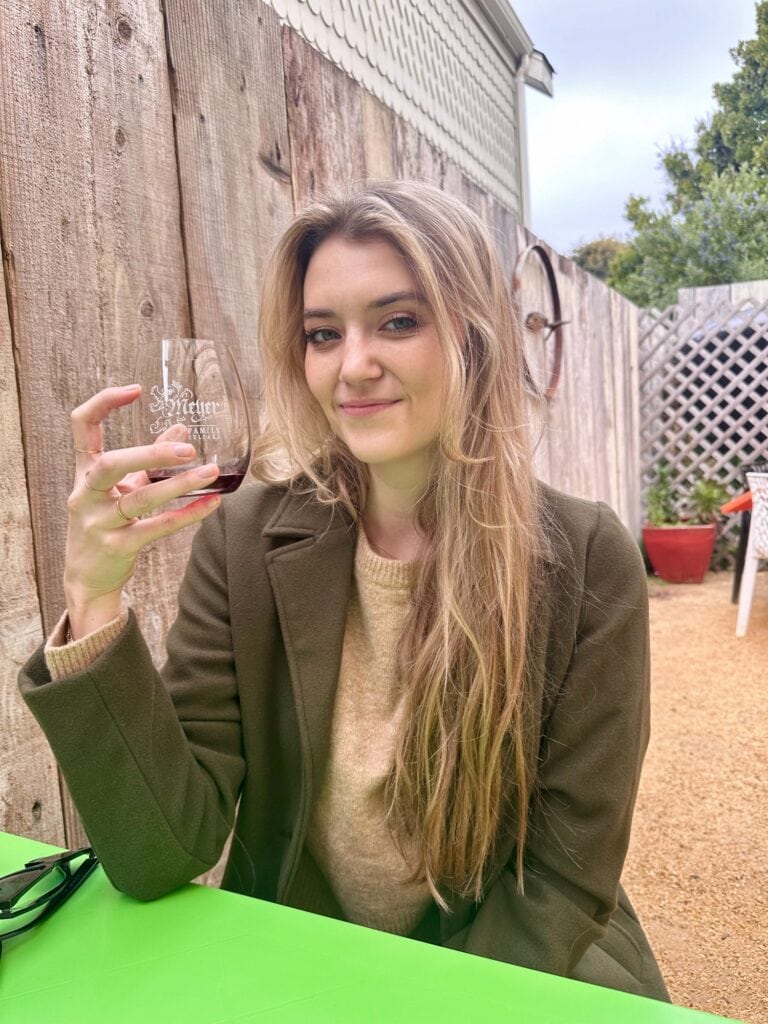 Woman smiling while holding a wine glass at Meyer Family Cellars tasting room