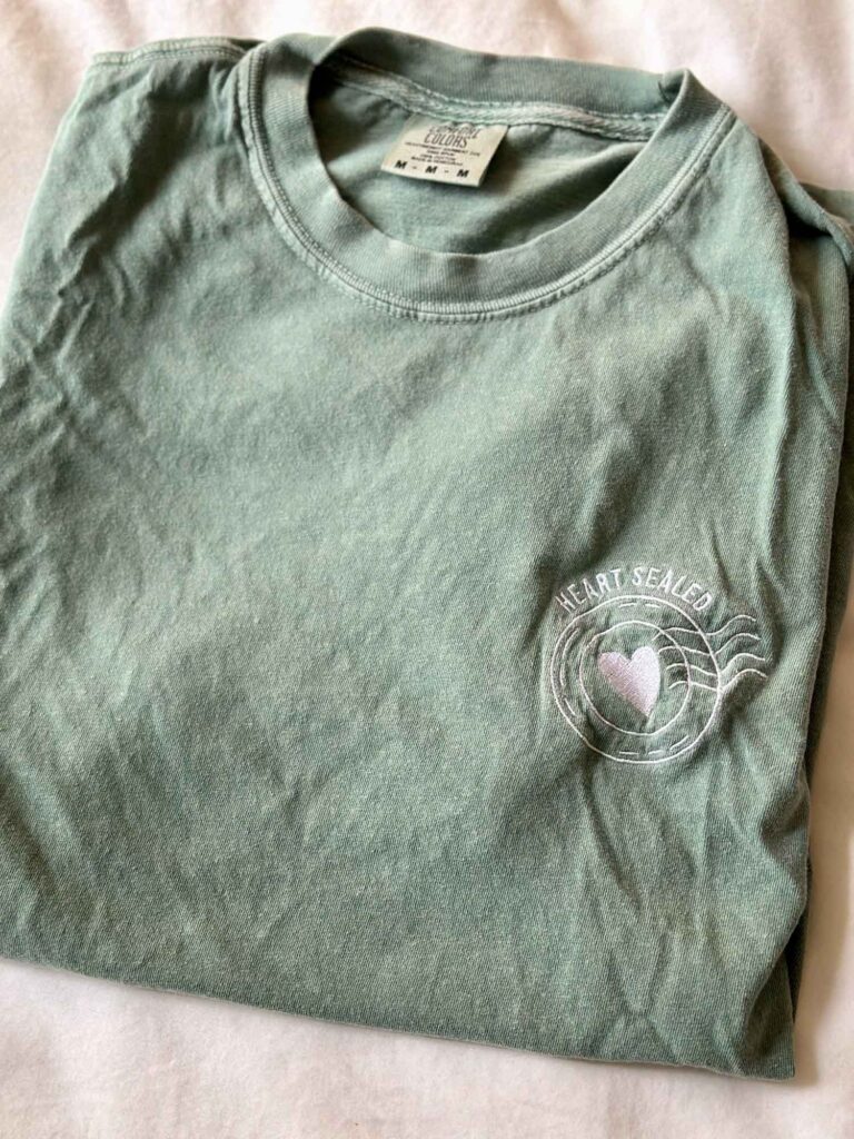 Soft green embroidered t-shirt that says “Heart Sealed” — a thoughtful and personalized gift idea from Etsy.