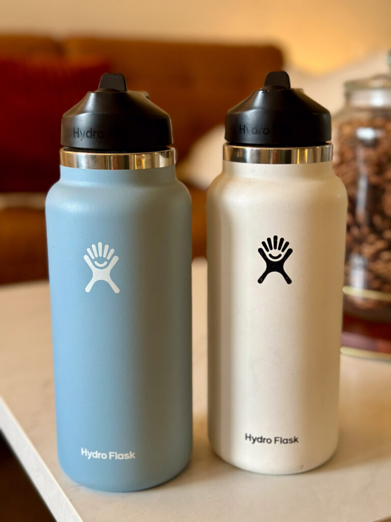 Blue and white Hydro Flasks on a coffee table — sturdy hydration essentials for on-the-go Enneagram 6s.