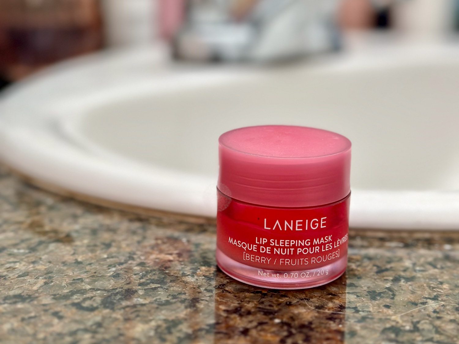 Pink jar of Laneige lip sleeping mask on a bathroom counter — beauty gift idea for skincare-obsessed Enneagram 7s.