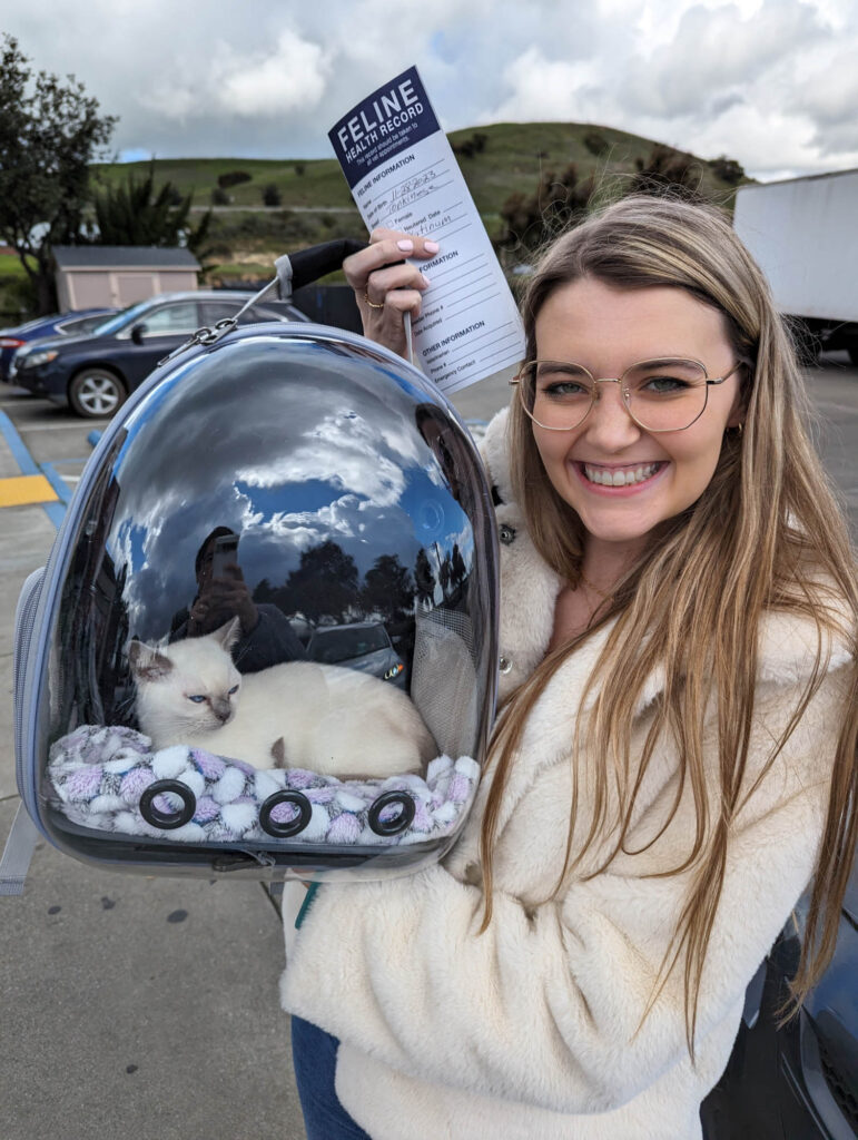 Woman holding a futuristic cat backpack with a clear dome — quirky and fun gift for cat lovers and adventurous Enneagram 7s.