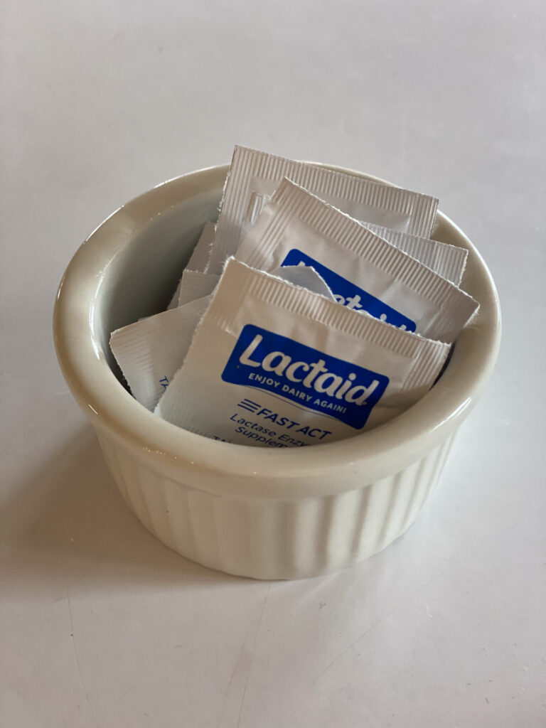 Small ramekin filled with Lactaid packets, a playful and practical touch for a dairy-friendly Asian charcuterie board.