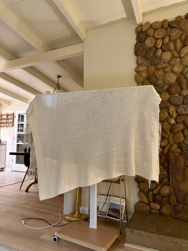 Television covered with a light blanket to recreate the pods from Love Is Blind during a themed watch party.