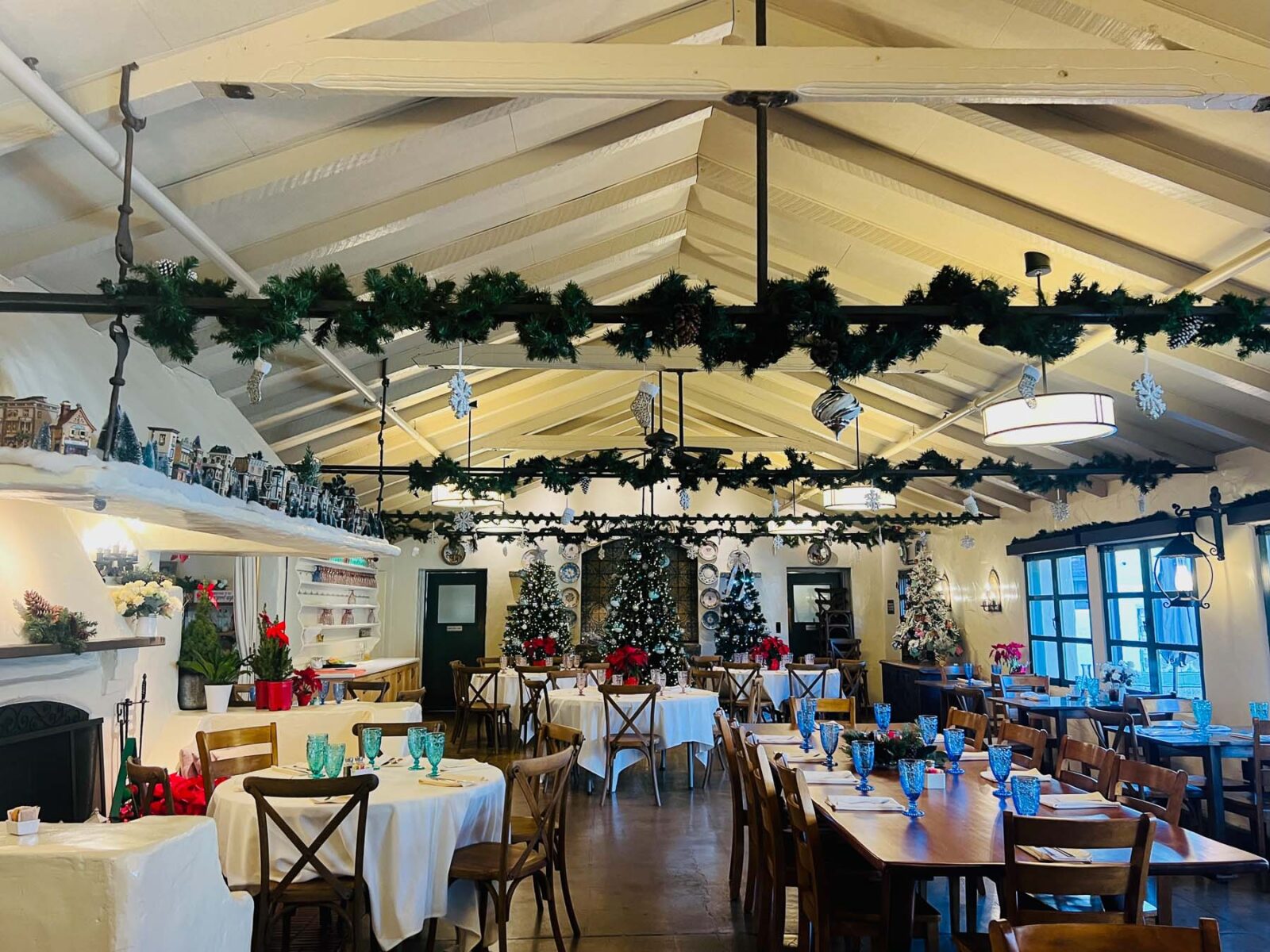 Cafe Wisteria at Allied Arts Guild decorated for Christmas with garlands, trees, and festive table settings.
