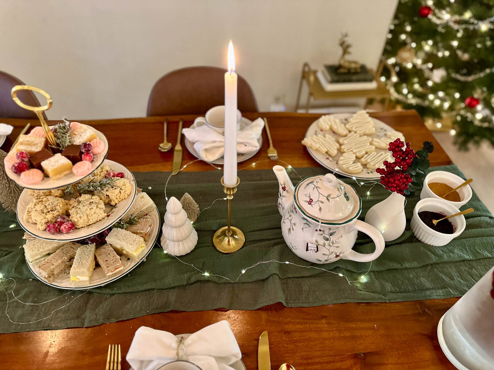 Christmas tea party table centerpiece with tiered tray, teapot, candles, and holiday table decor