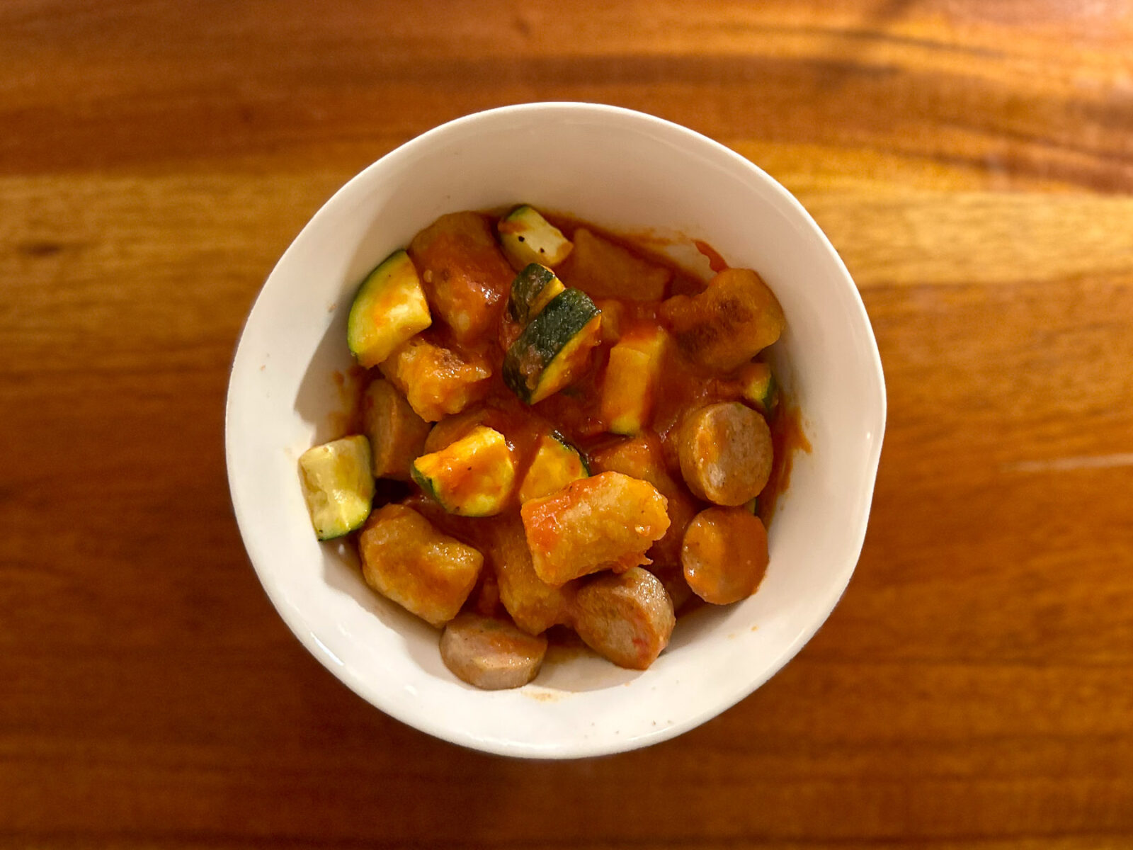 Bowl of sautéed cauliflower gnocchi with Italian-style chicken sausage, zucchini, and vodka sauce.