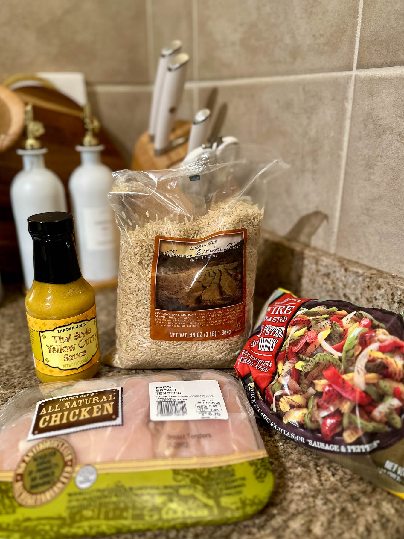 Trader Joe’s ingredients for Thai yellow curry, including chicken tenders, brown jasmine rice, Thai yellow curry sauce, and frozen fire-roasted bell peppers and onions.