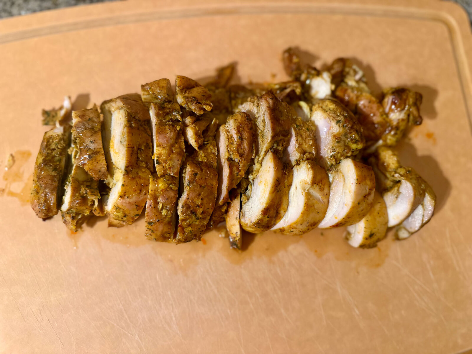 Cooked chicken shawarma sliced on a cutting board, showing juicy, well-seasoned pieces ready to serve.