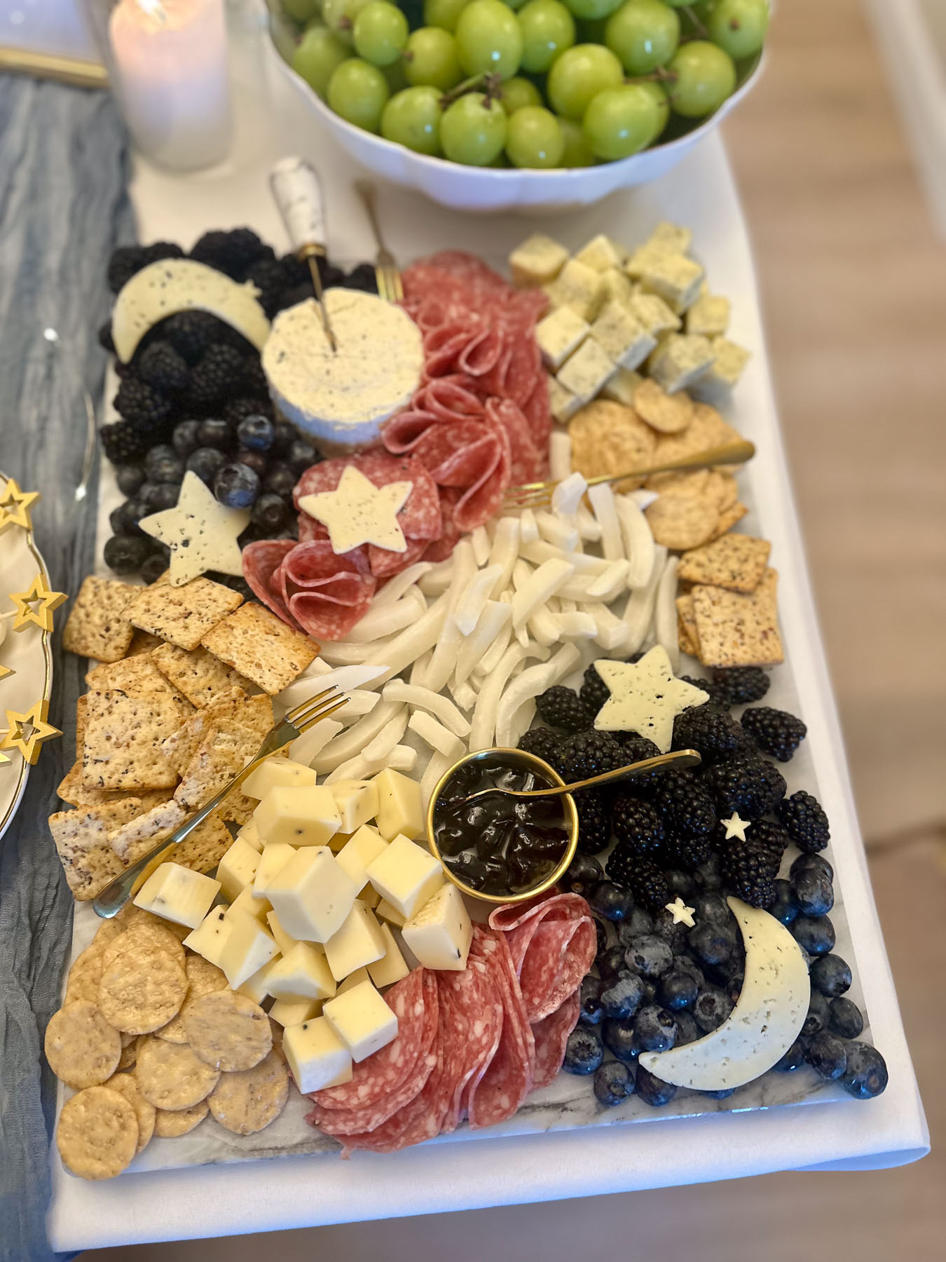 Baby shower charcuterie board with cheese, fruit, crackers, and star-shaped accents