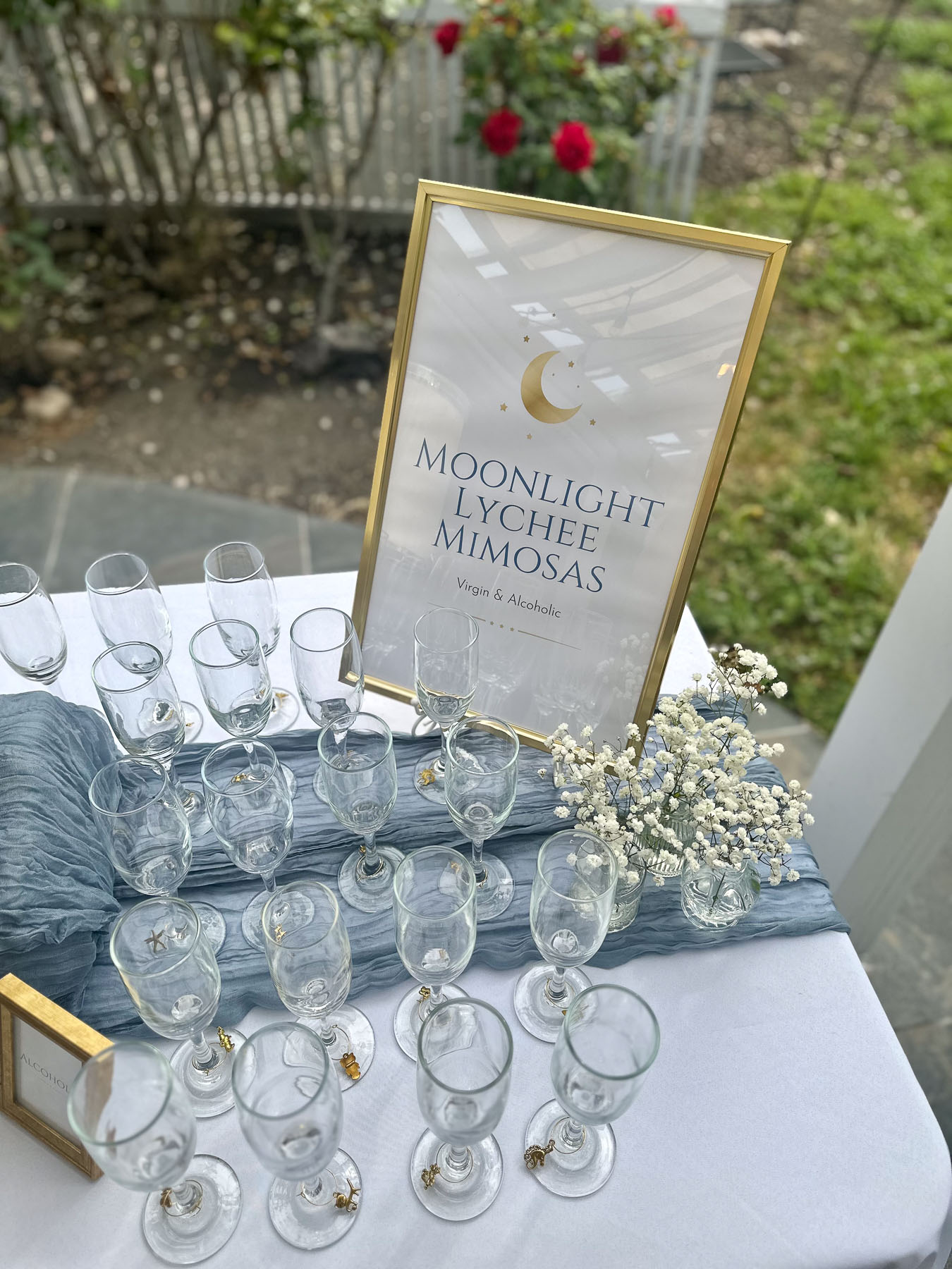 Moonlight Lychee Mimosas sign with glassware for a baby shower drink station