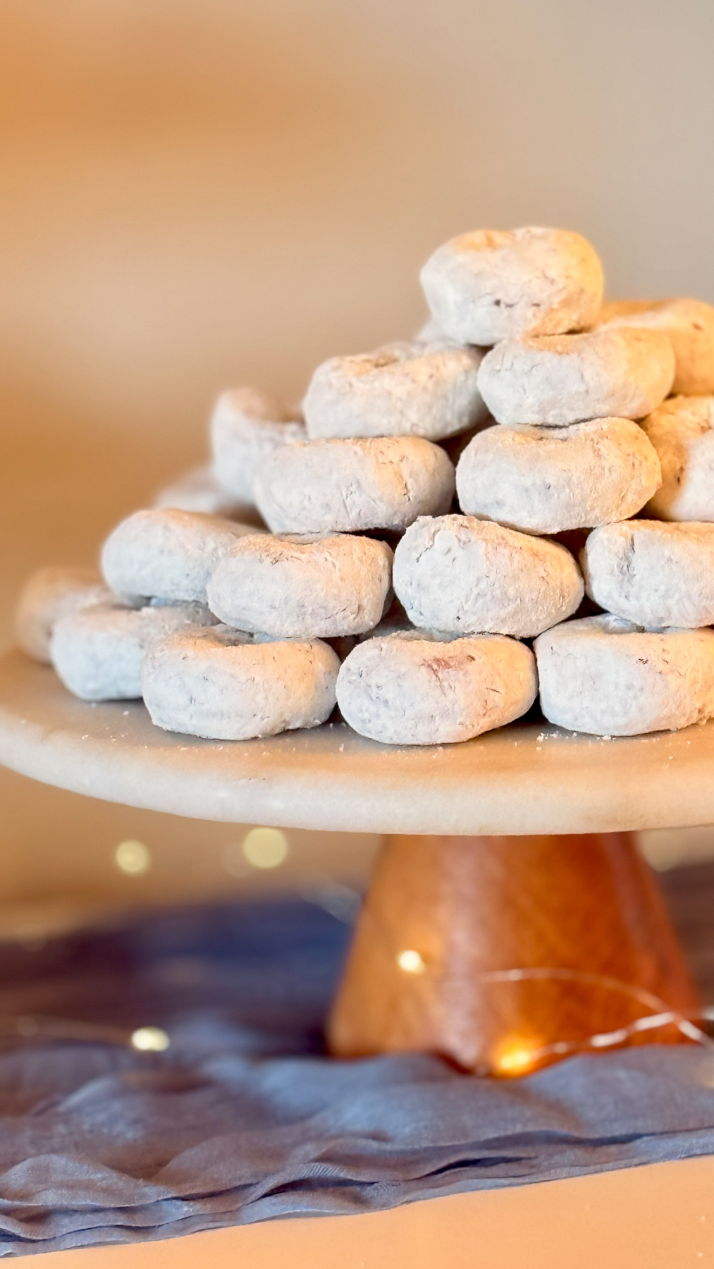Powdered sugar donuts styled as “star-dusted donuts” on a cake stand
