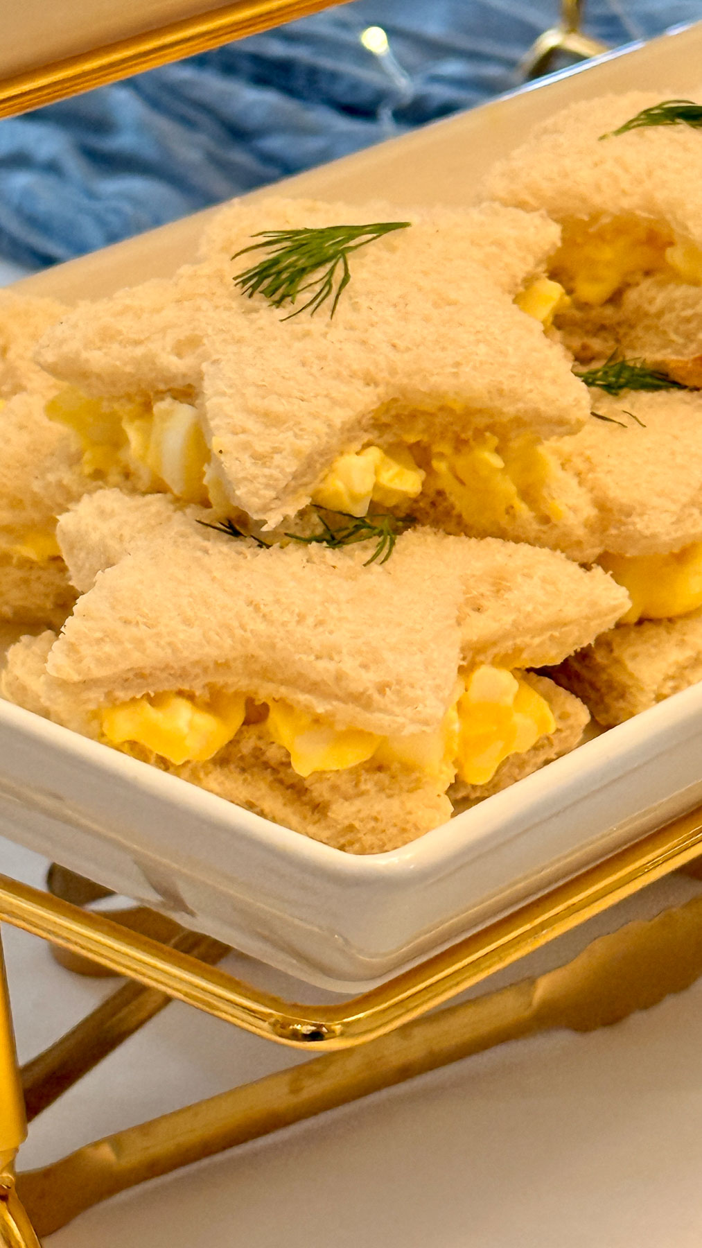Close-up of star-shaped egg salad tea sandwiches with fresh dill