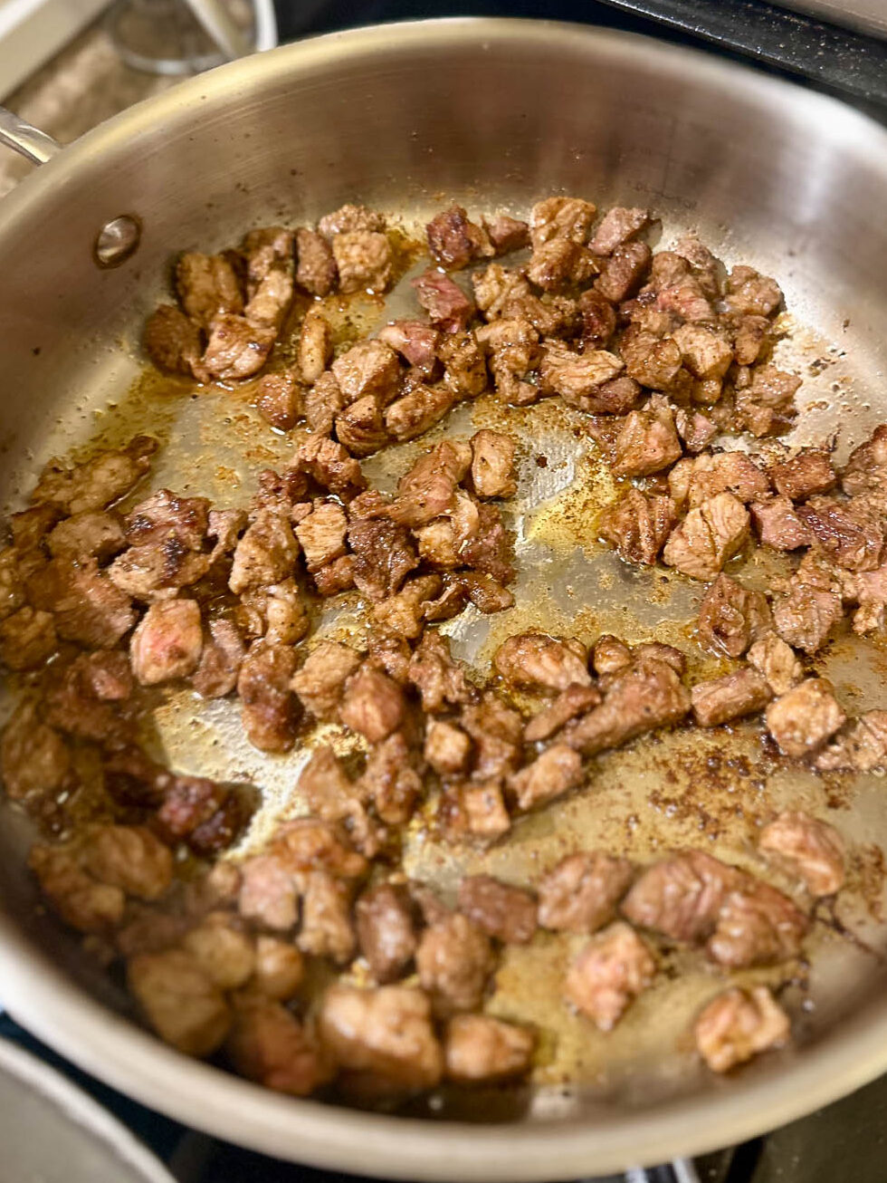 Fully cooked and browned seared ribeye steak pieces ready for tacos.