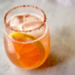 Grapefruit Paloma mocktail with Tajín rim, fresh grapefruit slice, and ice in a lowball glass.