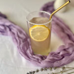 Lavender mocktail with lemon and elderflower in a glass with fresh lavender on a lavender table runner