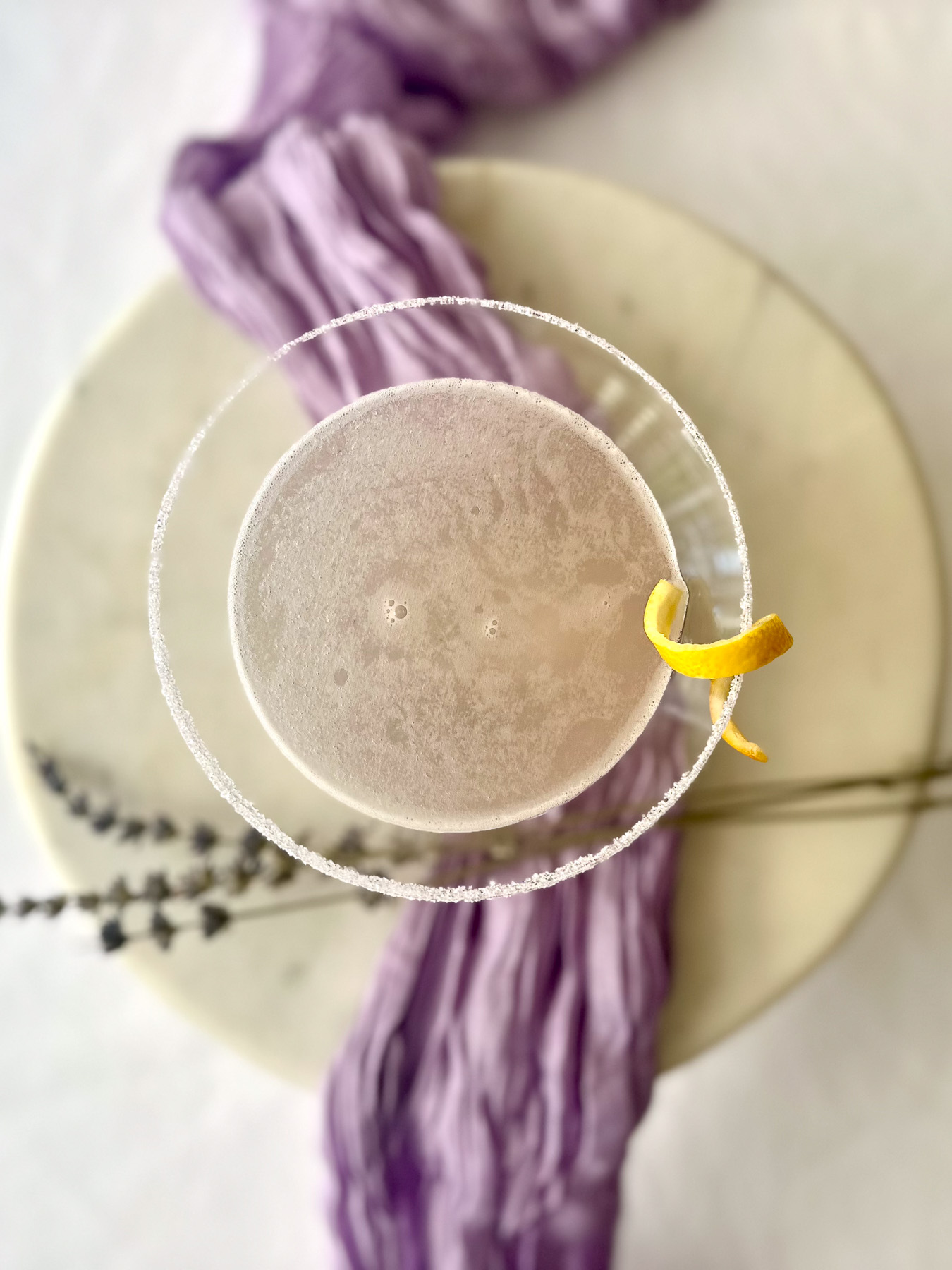 Lavender lemon drop martini with a sugared rim and lemon twist garnish.